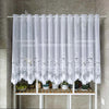 White lace mesh sheer curtain hanging in a rod pocket with potted plants below