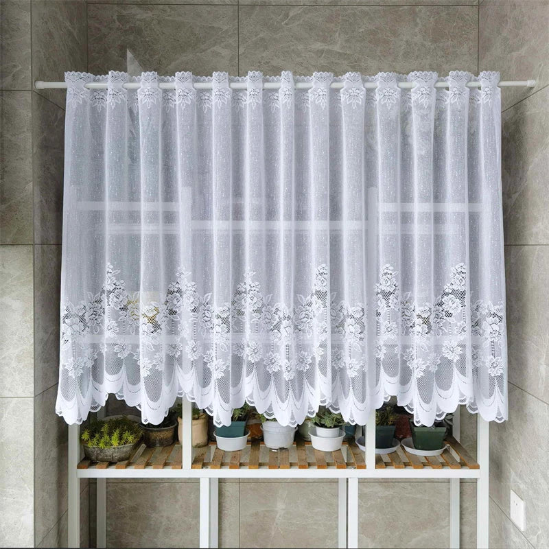 White lace mesh sheer curtain hanging in a rod pocket with potted plants below