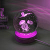 A crystal ball night light featuring glowing purple light and an image of a jellyfish inside.