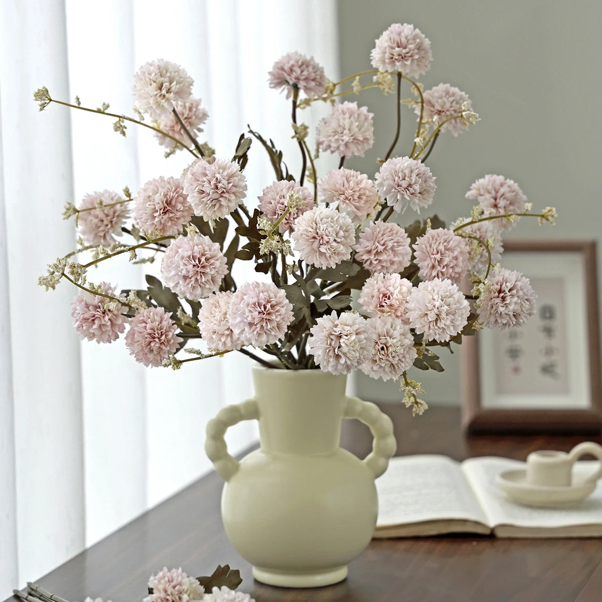 A bouquet of pink silk chrysanthemum artificial flowers displayed in a light ceramic vase.