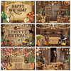 A rustic western backdrop featuring a wooden barn door, cacti, leather boots, and various rustic props.
