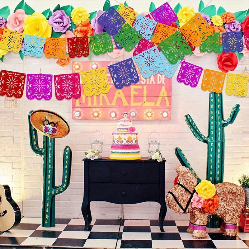 Colorful papel picado banners in various colors decorate a wall with a cactus and a dresser.