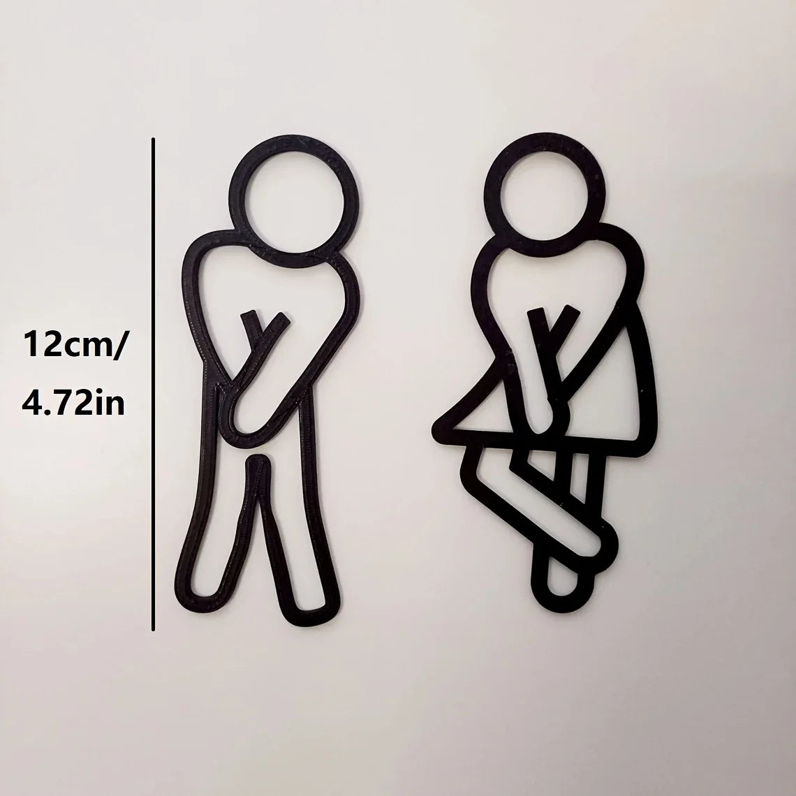 Deux panneaux de porte silhouettes noires montrant une figure debout et une figure assise, avec une échelle indiquant 12 cm o