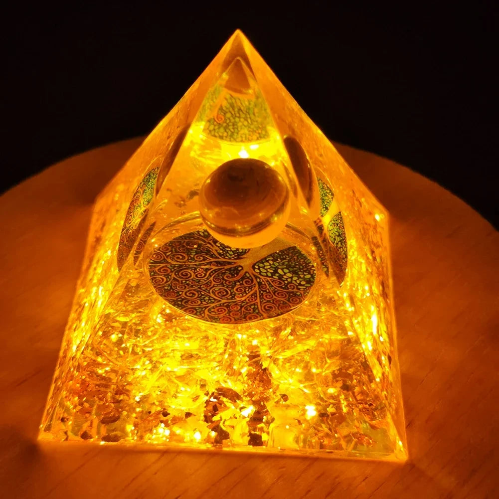 Handmade resin orgonite pyramid glowing with natural obsidian and copper coil