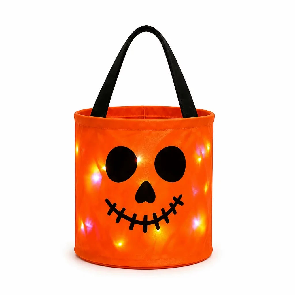 An orange pumpkin-shaped candy bucket with a black handle that glows with internal LED lights.