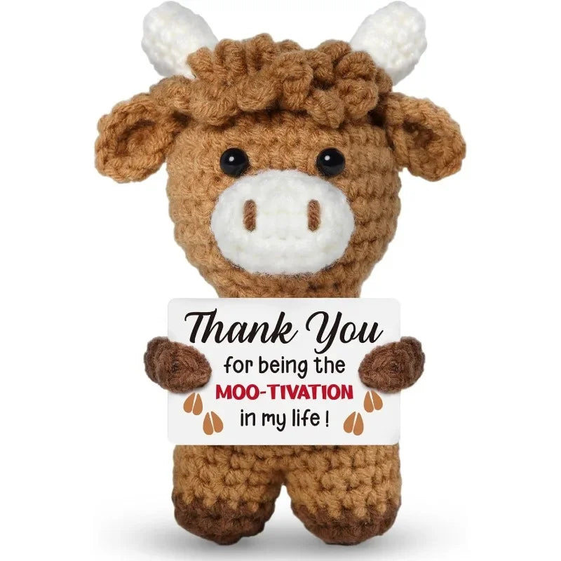 A brown crocheted animal doll with white accents, featuring a card that reads Thank You for being the moo-tivation in my life