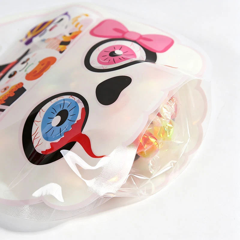 A clear plastic bag filled with Halloween pumpkin witch treat bags featuring pink and black designs.