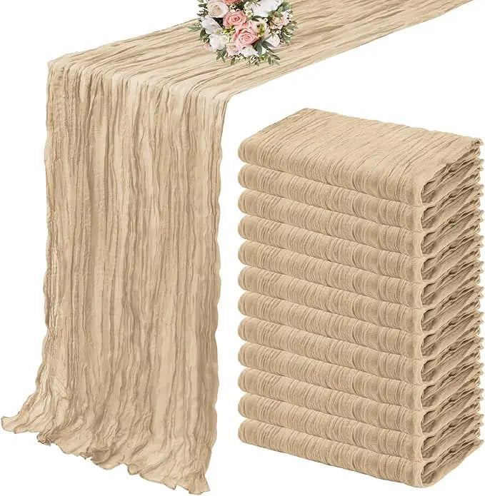 A set of ten terracotta semi-sheer cheesecloth table runners in a beige color stacked and displayed.