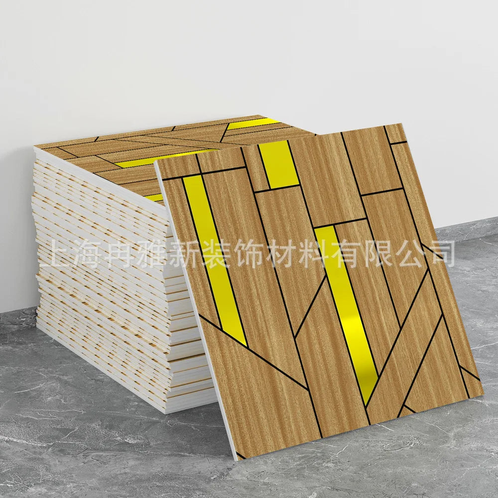 A stack of marble peel-and-stick tiles featuring a wood grain pattern with gold accents, displayed on a gray surface.