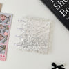 A clear transparent photocard album featuring a mushroom hole design resting on a white surface.