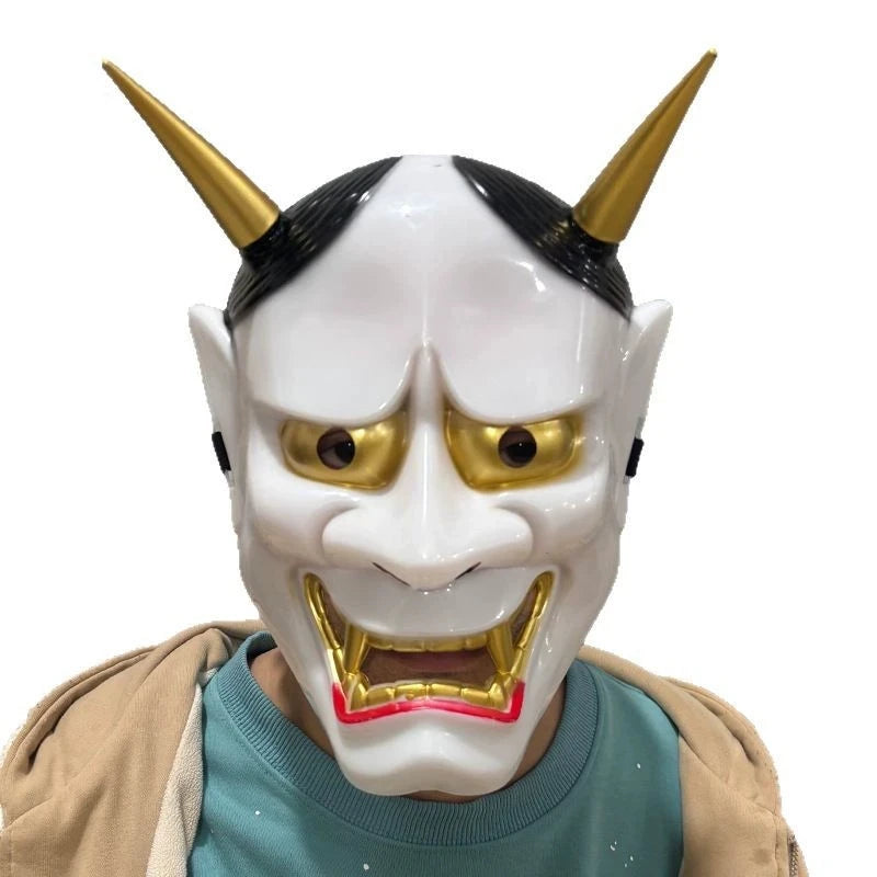 A full face Japanese Hannya demon mask with horns and golden eyes displayed on a person's face.