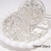 A clear glass petri dish filled with small round spacer beads, some are visible in a magnifying glass.