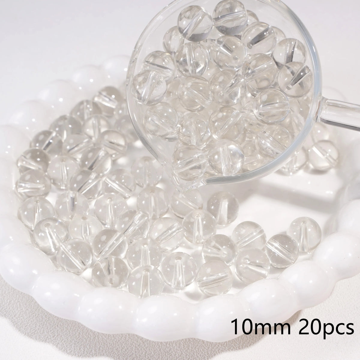 A clear glass petri dish filled with small round spacer beads, some are visible in a magnifying glass.
