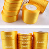 Rolls of gold yellow satin ribbon in various widths and lengths for crafts and gift wrapping