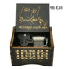 A wooden music box featuring an anime character design on the lid and decorative carving on the base.