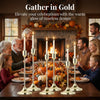 A set of gold metal taper candle holders arranged on a wooden table in front of a fireplace.