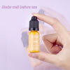 A hand holds a small yellow bottle of liquid colorant labeled Yellow for candle wax making.
