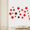 Red and black star shapes arranged in a scattered pattern on a white wall.