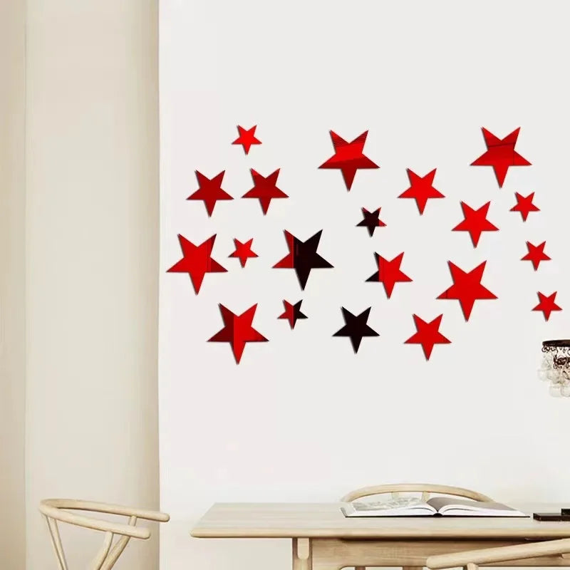 Red and black star shapes arranged in a scattered pattern on a white wall.