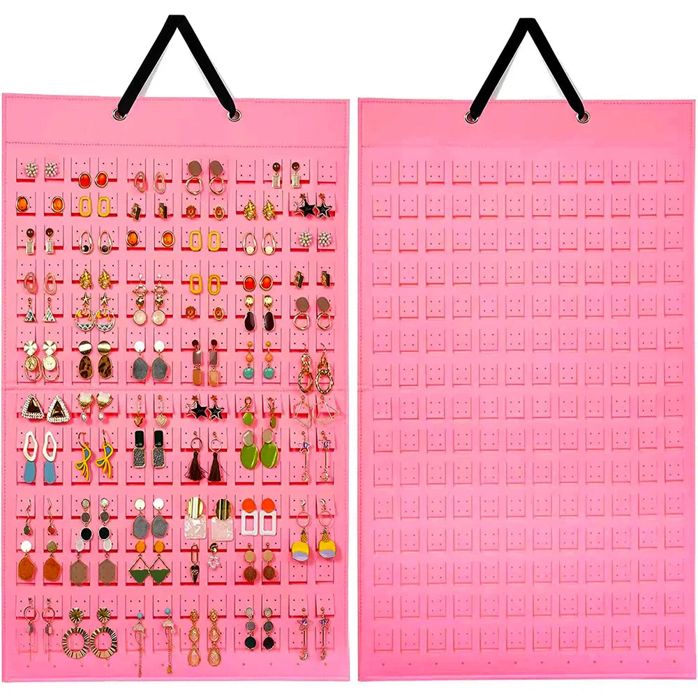 A pink felt organizer display showing various jewelry and earrings arranged in small compartments.
