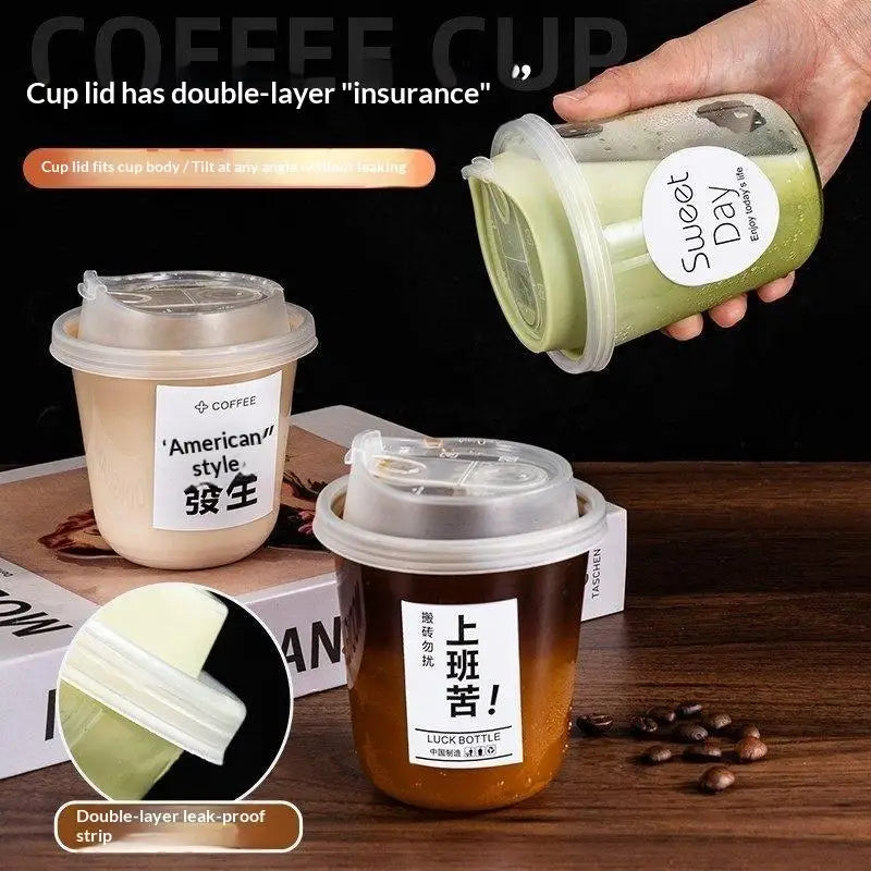 Una mano sostiene una taza desechable verde con tapa, demostrando su característica de doble capa de seguro.