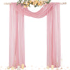 Tissu de mousseline rose drapé formant un élégant décor d'arche avec des accents floraux