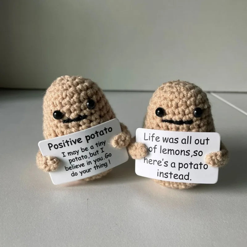 Two handmade knitted plush dolls shaped like potatoes with handwritten messages