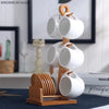 A white ceramic coffee mug set is displayed on a natural bamboo wood stand.