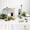 A set of three elegant gold metal candle holders displayed against a white background.