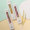 A set of six metallic twisted coil birthday candles in various colors are displayed on a light green and beige background.