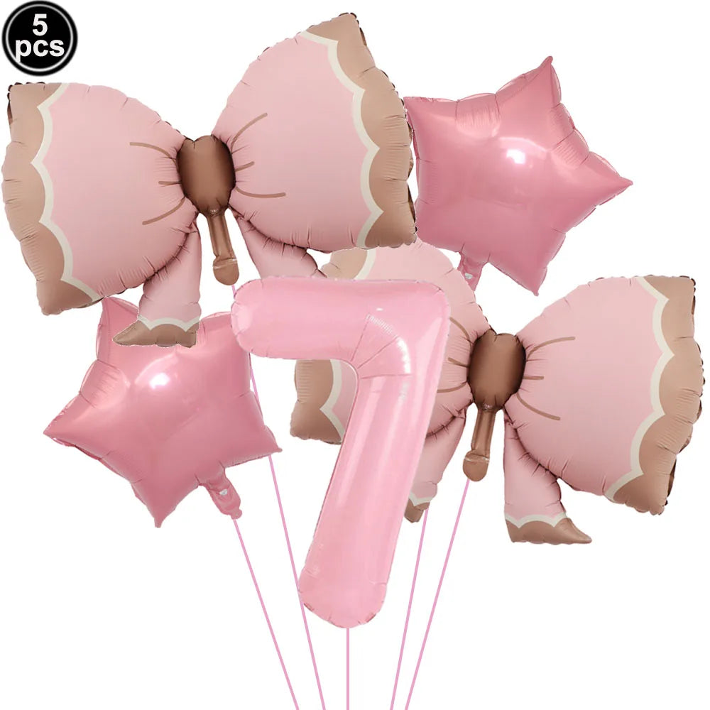 A set of pink bow disposable party tableware, including star-shaped decorations and a number seven balloon.
