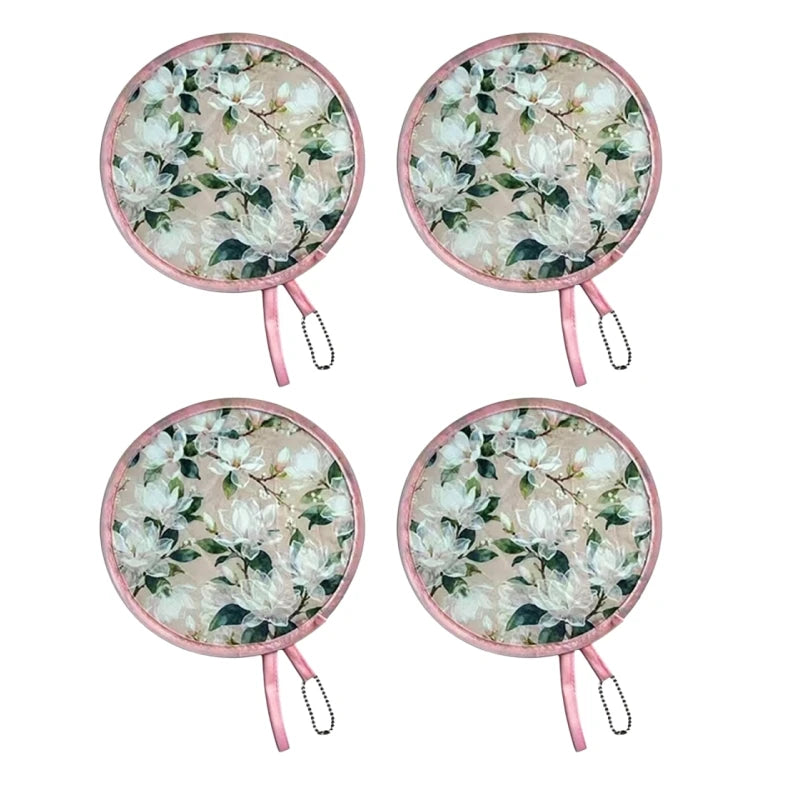 A pair of light pink floral foldable pocket fans with white and green leaves.