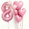 Pink foil balloons shaped like the number 8 and hearts with pink bows for party decoration