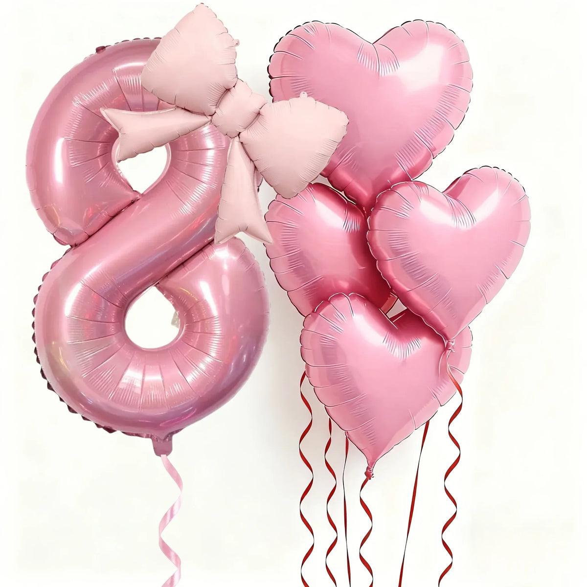 Pink foil balloons shaped like the number 8 and hearts with pink bows for party decoration