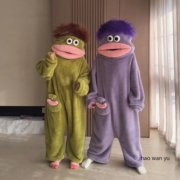 A pair of fuzzy, green and purple monster coral fleece hooded sleepsuits for women.
