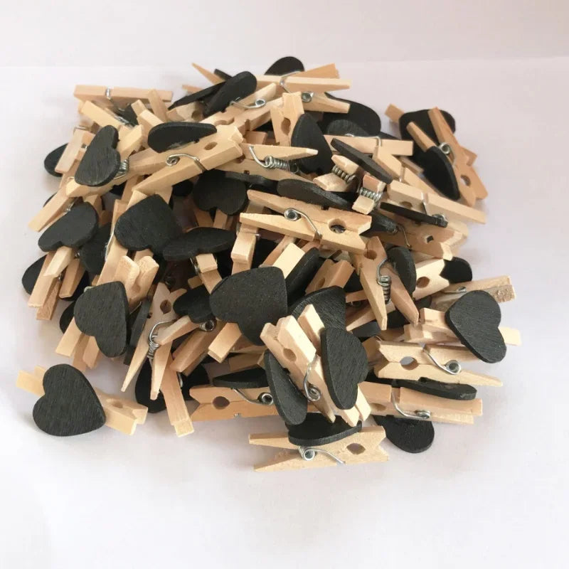 A pile of mini wooden photo clips shaped like hearts for crafts and display