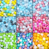 A collection of colorful, translucent plastic balls in various shades including blue, pink, yellow, and white.