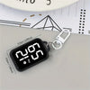 A black LED keychain pocket watch with a digital display showing 2:09 PM on a gray surface.