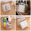 Boîte de rangement pour bureau en acrylique transparent contenant divers articles de papeterie comme carnets et stylos.