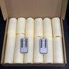 A cardboard box containing four white flameless LED candles with remote controls.
