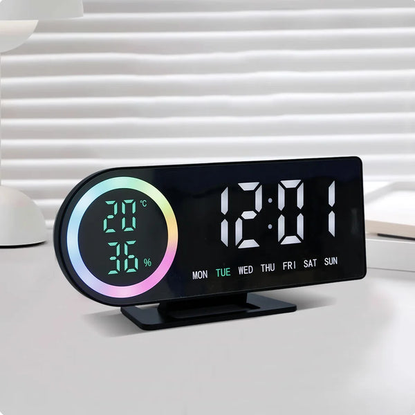 A black LED digital alarm clock displaying the time 12:01, temperature 20°C, and humidity 36%.