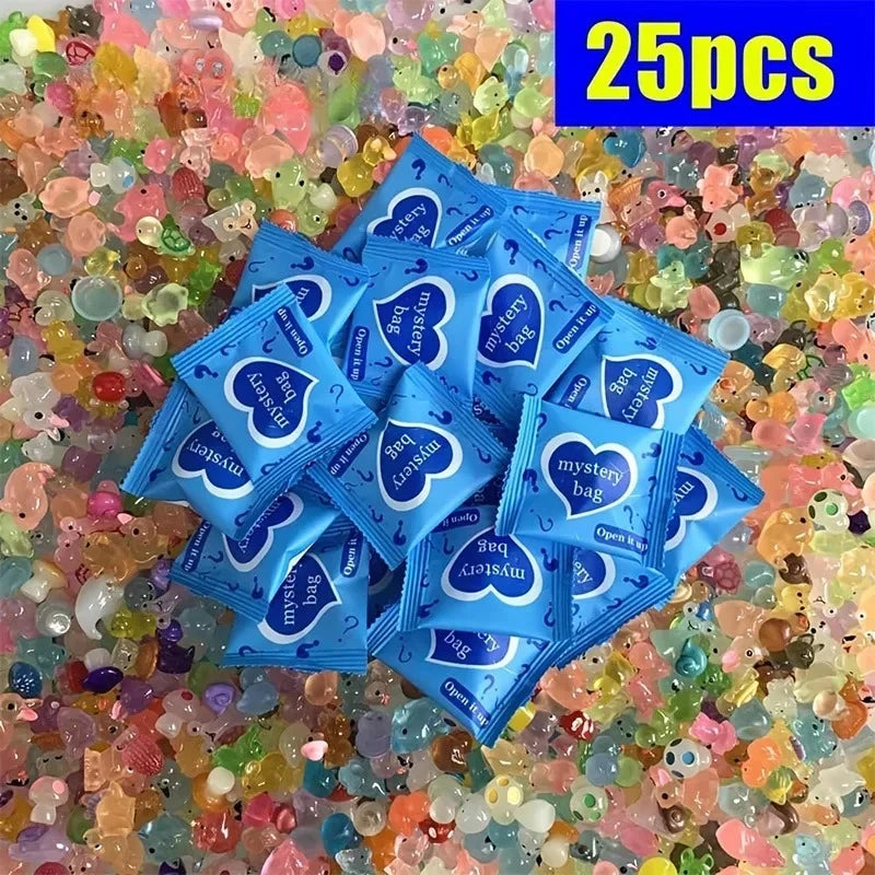 Une pile de 25 sacs mystère bleus avec des motifs de cœur éparpillés sur des perles colorées et translucides.