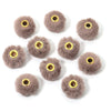 Collection de petites boules de fourrure grise et duveteuse utilisées comme perles pour la création de bijoux DIY.
