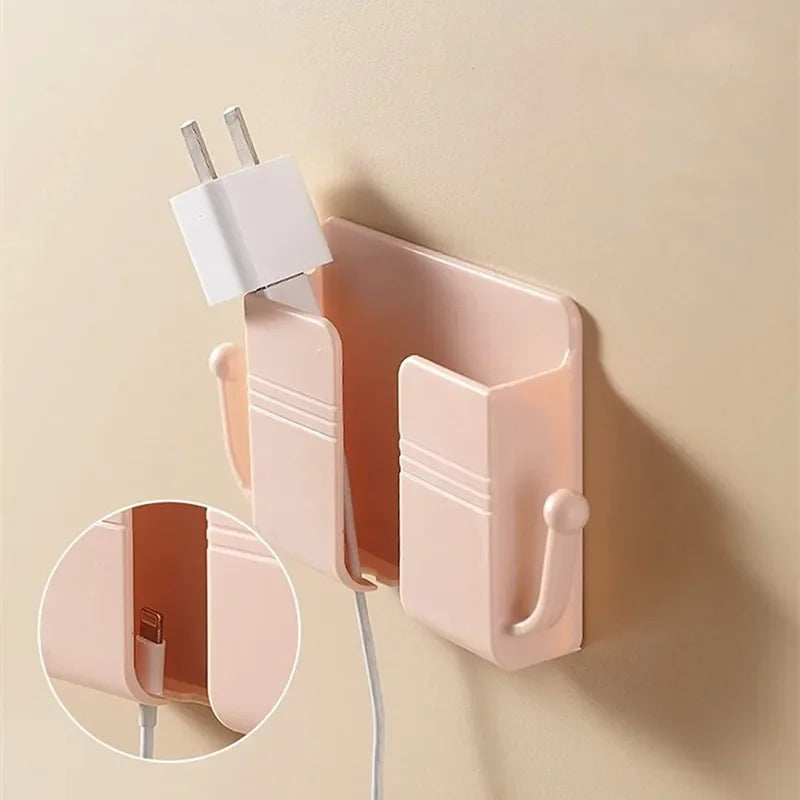 A pink wall-mounted organizer with a phone holder and charging dock is shown against a beige wall.