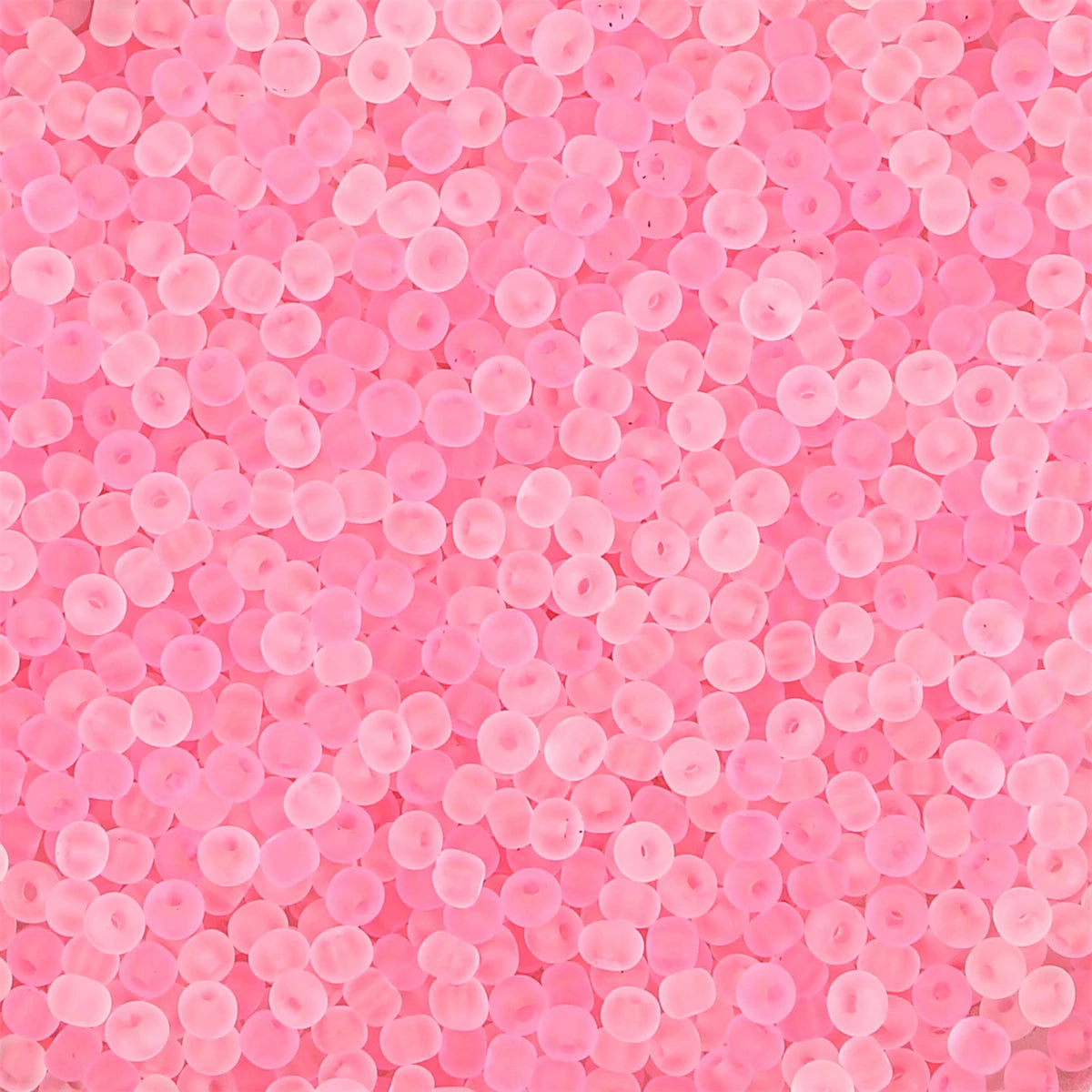 Close-up view of pink frosted glass rice beads for jewelry making
