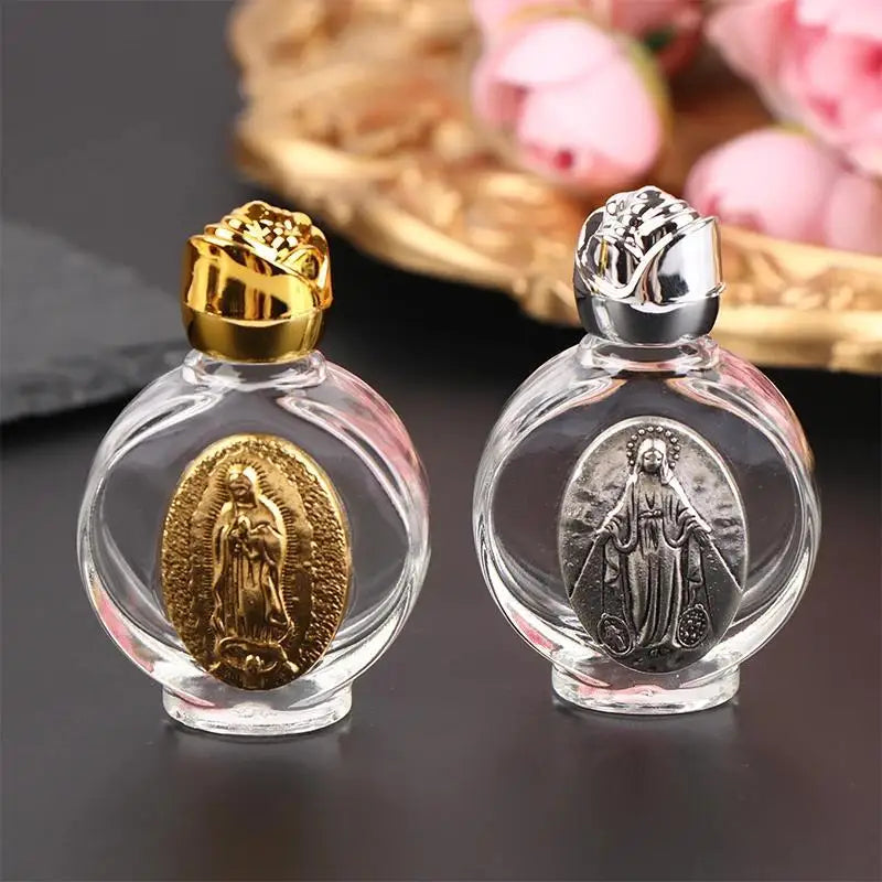 Clear glass holy water bottle with a gold and silver religious sculpture inside