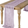 A purple semi-sheer gauze table runner draped over a wooden table.