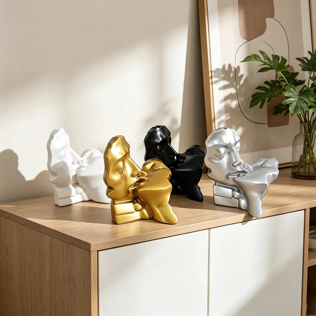 A collection of abstract resin sculptures depicting a kissing couple in white, gold, black, and silver finishes.