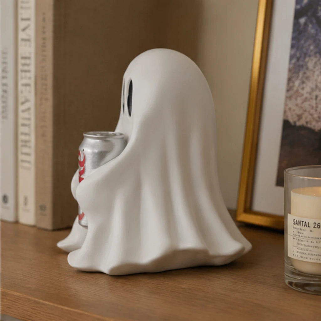 Figurine fantôme blanche tenant une canette d'aluminium, exposée sur une surface en bois.