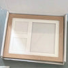 A photo frame containing two square spaces for photos, set in a wooden frame and packaged in a box.